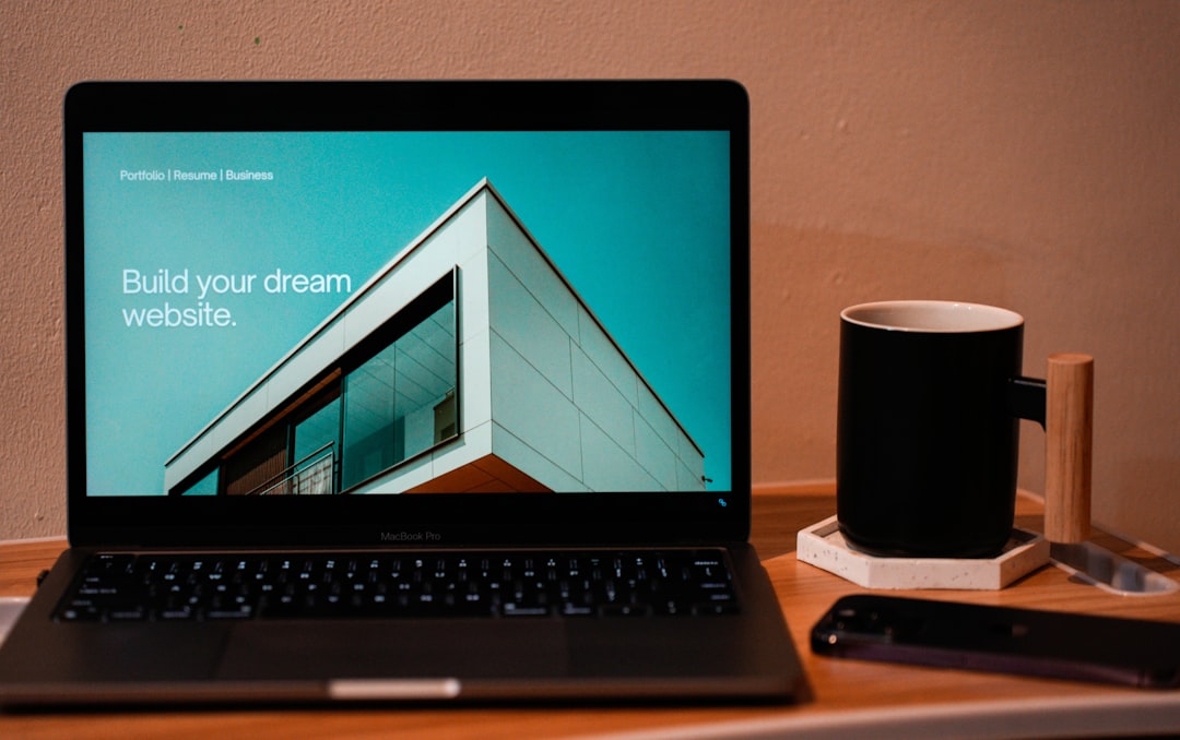 services-02 Create the website you’ve always envisioned for your future. A laptop, MacBook, sitting on a portable table with a coffee or tea mug beside it.